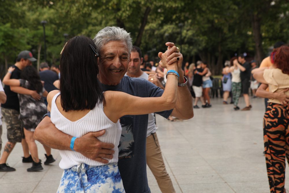 Personas bailando en una plaza de La Plata durante actividades culturales al aire libre