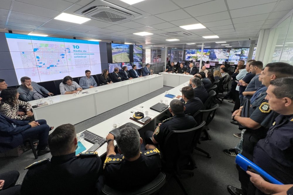 Reunión de autoridades en el Centro de Operaciones Municipal de La Plata analizando mapas del delito en pantallas