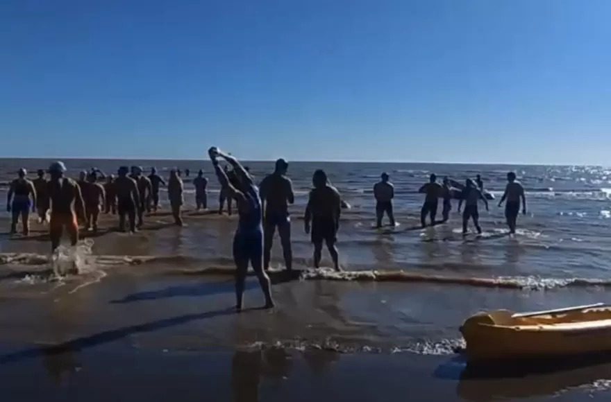 Participantes entrando al agua en el acuatlón Corremos por la Memoria en Berisso