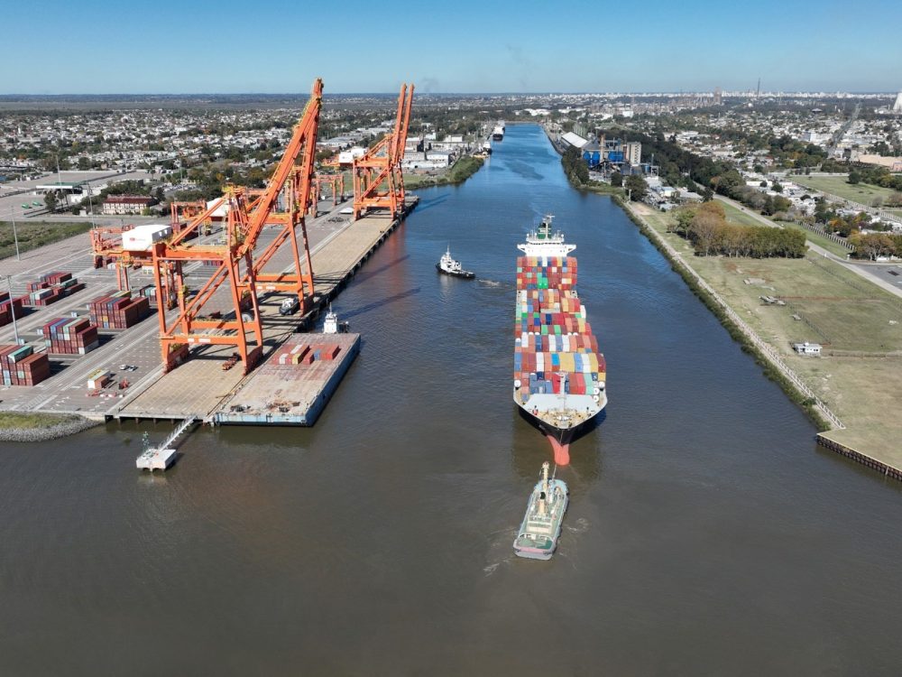 Barco portacontenedores ingresando al Puerto La Plata en el canal con vista aérea de la región capital