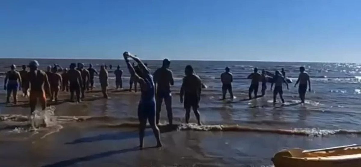 Participantes entrando al agua en el acuatlón Corremos por la Memoria en Berisso